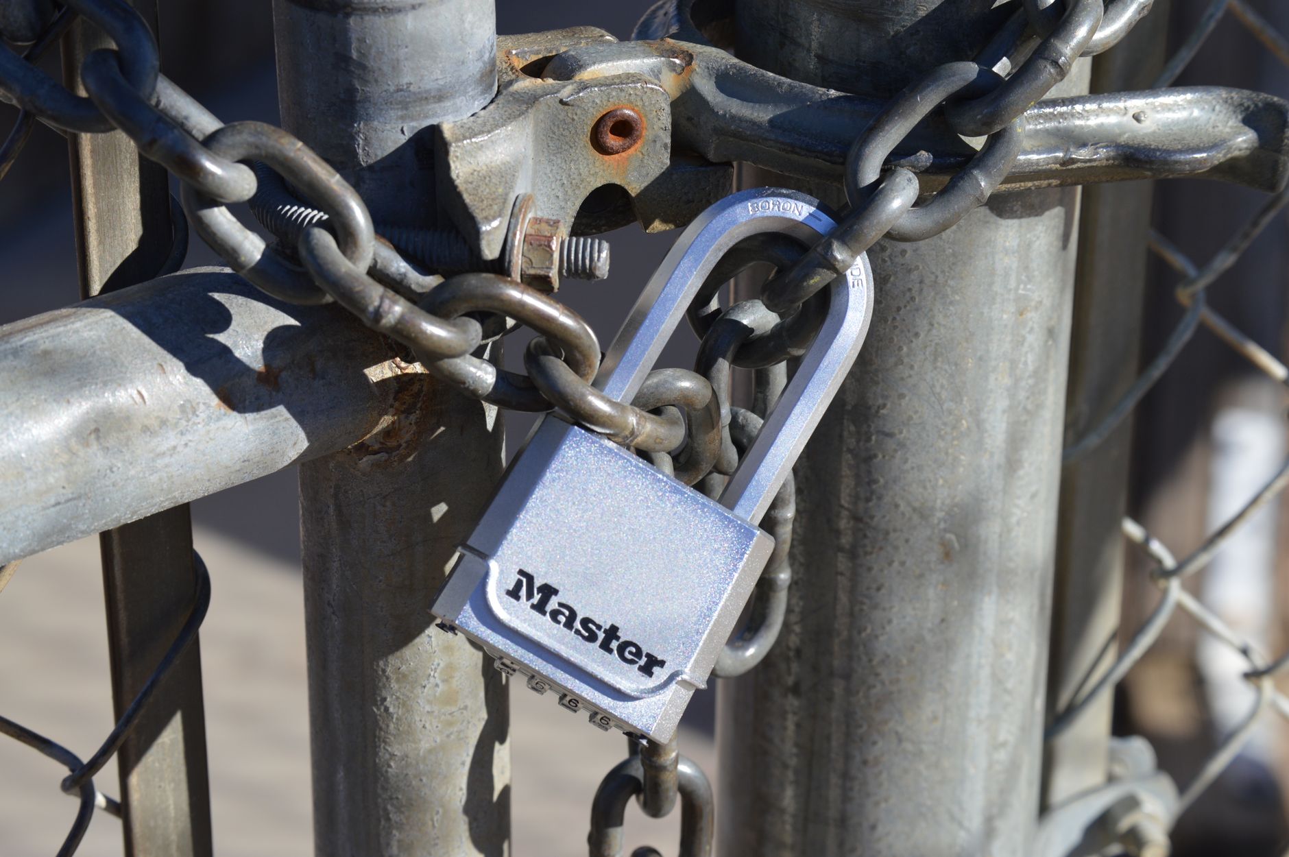 Detailed view of a padlock securing a metal gate with a chain, emphasizing safety and security. (Photo by Larkin Hammond on Pexels)