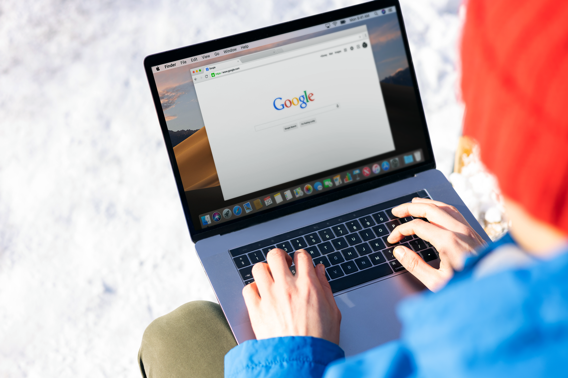 Individual typing on a laptop outdoors with snow, accessing the internet. (Photo by Firmbee.com on Pexels)